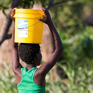 Water: Carrying the Burden - Child Carrying Water Bucket