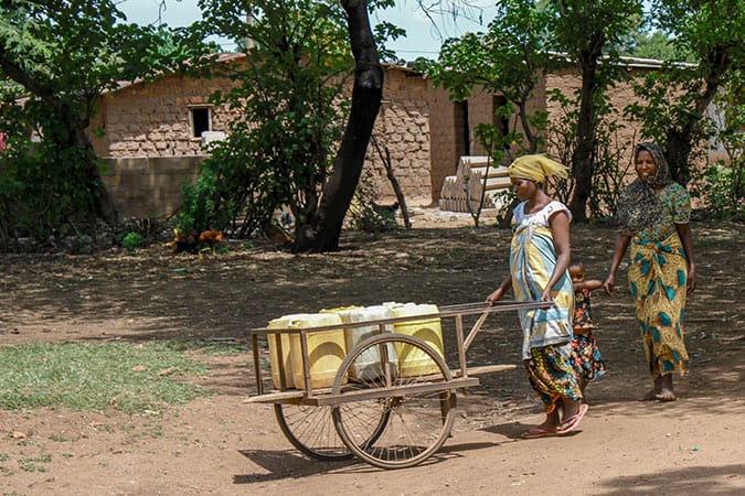 Water: Carrying the Burden - Woman Carting Water Containers