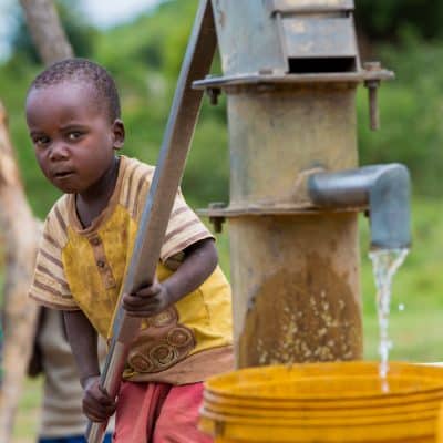Small Boy Fills Bucket from Water Well
