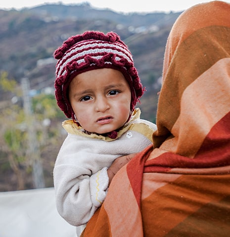 Refugee child held by her mother