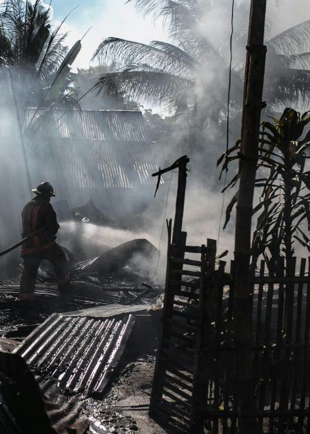 firefighter sifts through burned area